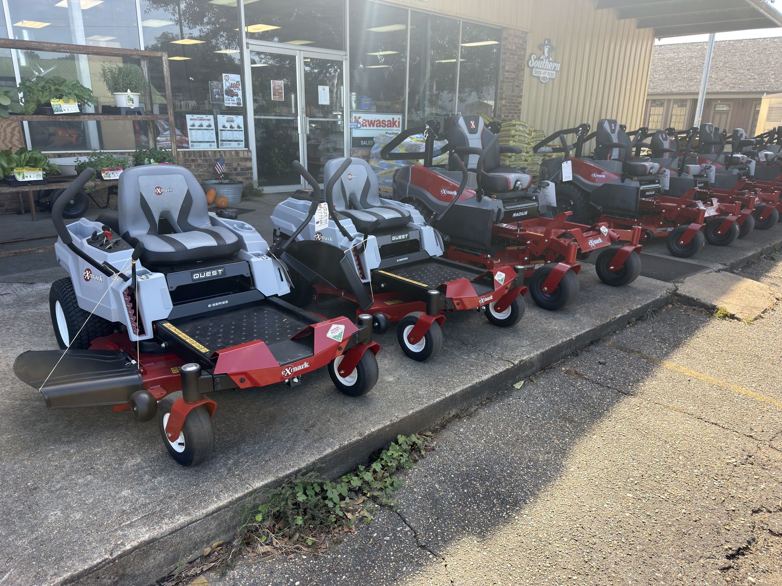 Exmark Quest and Radius zero-turn mowers on the sidewalk at Feeders Milling