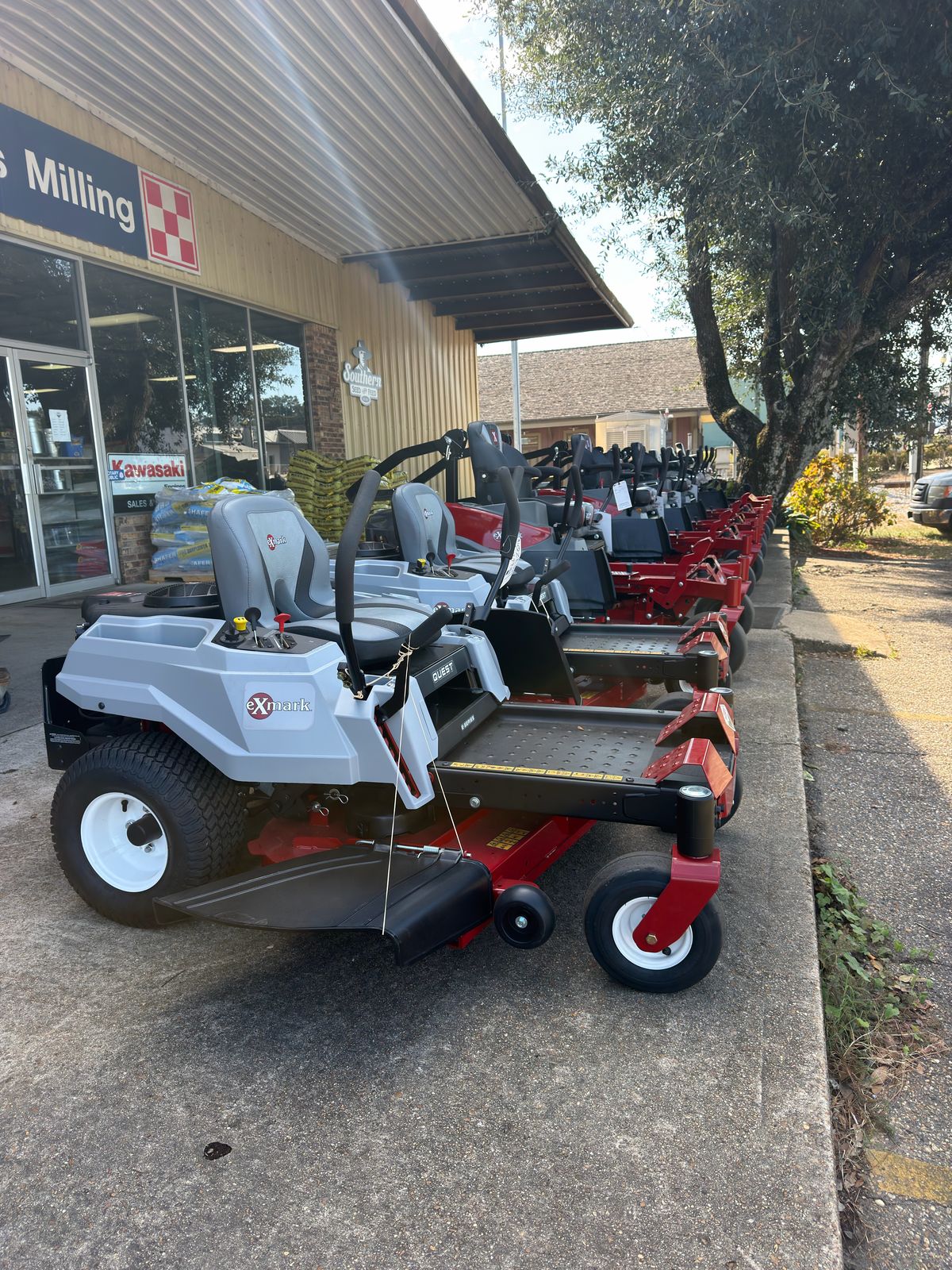 Row of Exmark zero-turn lawn mowers lined up outside Feeders Milling